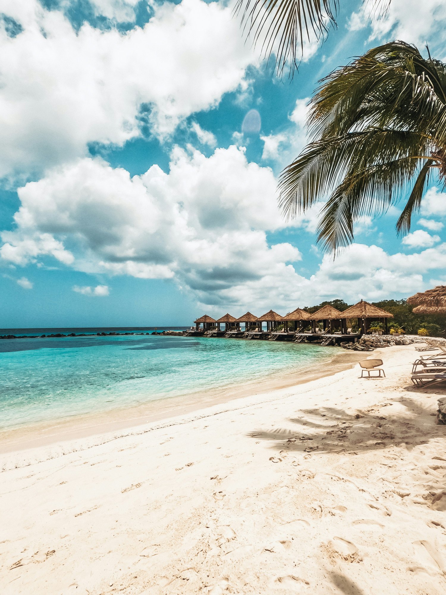 Aruba white sand beach with turquoise water and thatched beach huts